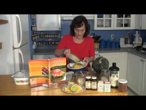 Woman preparing dish in a kitchen with ingredients.