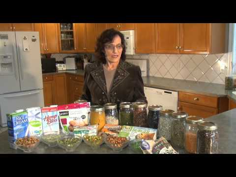 Woman with various grains and legumes in kitchen