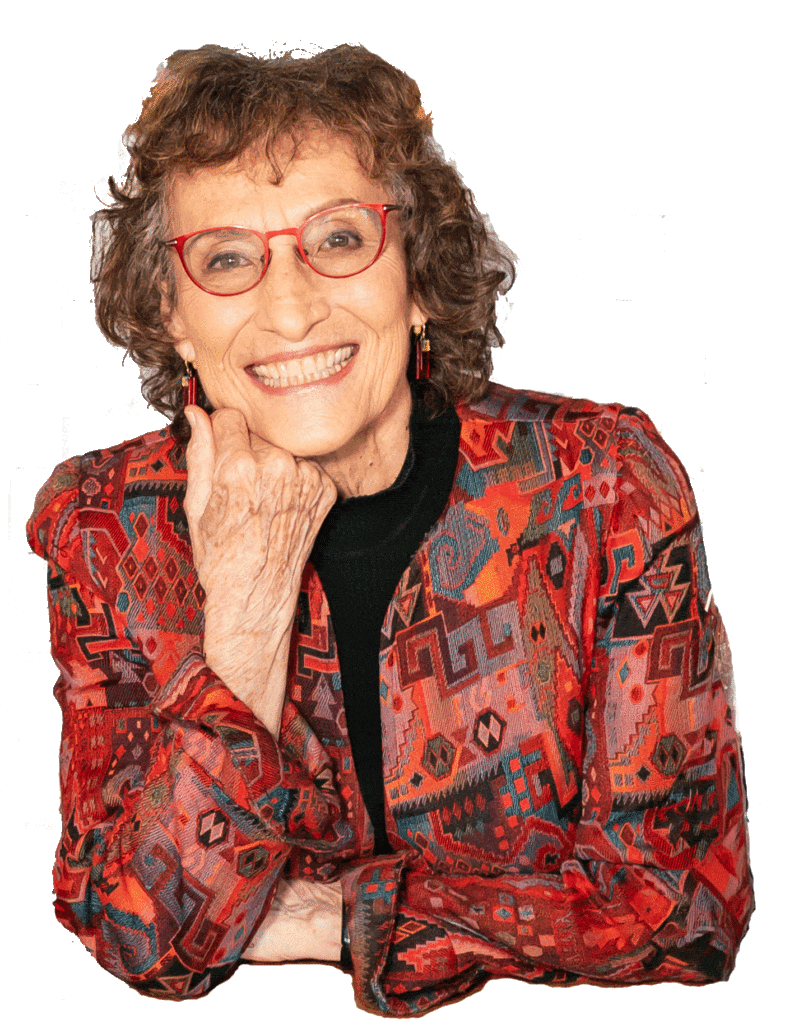 Smiling woman in vibrant patterned jacket and glasses.